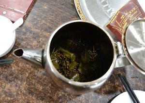 A metal teapot filled with loose leaf tea