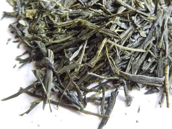 Loose-leaf green tea showing intact long, flat, pointy leaves with dark green color
