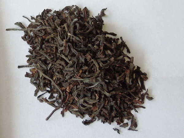 Black tea leaves with some reddish-olive hues, slightly curved, a few slightly broken pieces