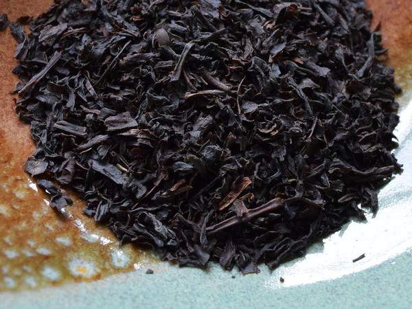 Moderately broken black tea leaves, dark, in a ceramic dish