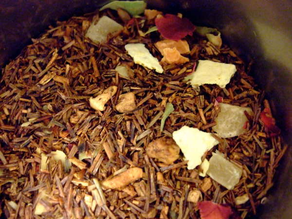 Mix of bronze-red rooibos leaf and stem with chunks of various other ingredients