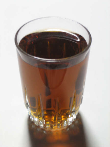 Glass filled with dark brown transparent drink