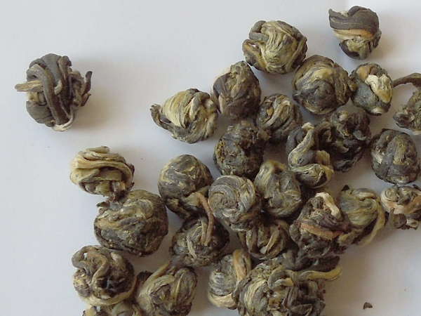 Small round balls made up of rolled-up tea leaves, silvery-golden to gray-green in color