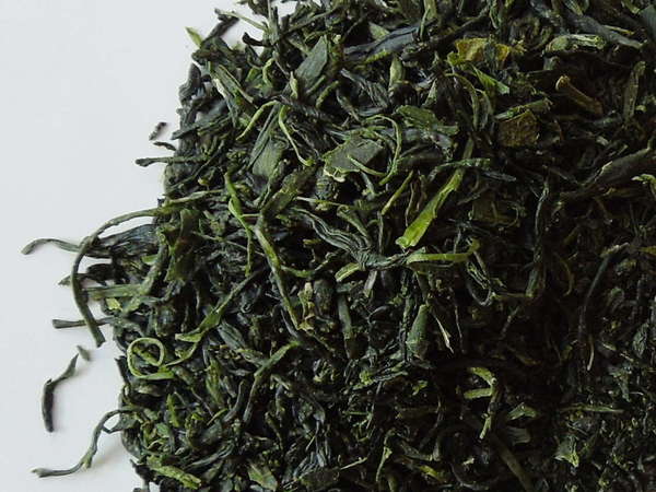 Loose-leaf green tea with vibrant dark green color and wiry, slightly curved leaves