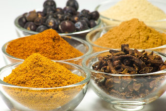 Bowls with blueberries, cloves, and ground spices