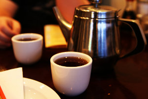 Two small Chinese teacups and a metal teapot