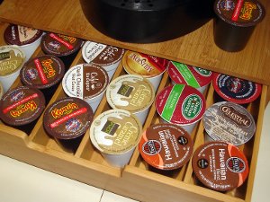 An assortment of Keurig K-Cups with colorful caps in a wooden drawer