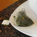 A used tea sachet filled with wet green tea leaves