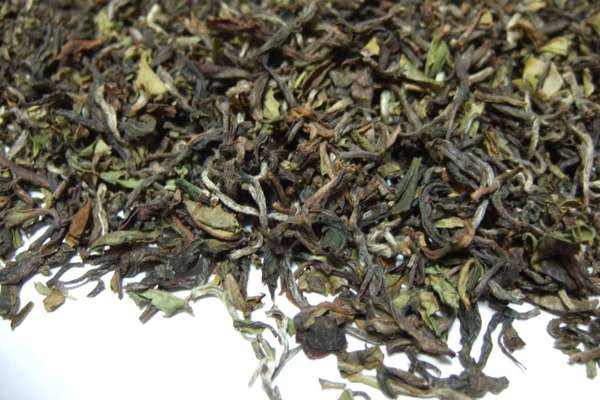 Tea leaves with greenish, olive, and silvery colors, with irregular, gently curved shapes