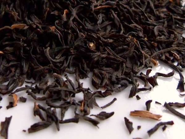 Very dark loose-leaf tea with a few flecks of lighter orange colors interspersed
