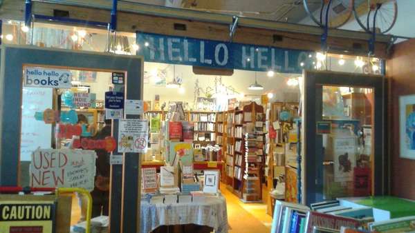 Colorful entryway to a bookstore, Hello Hello written above the doorway, lots of signs all over