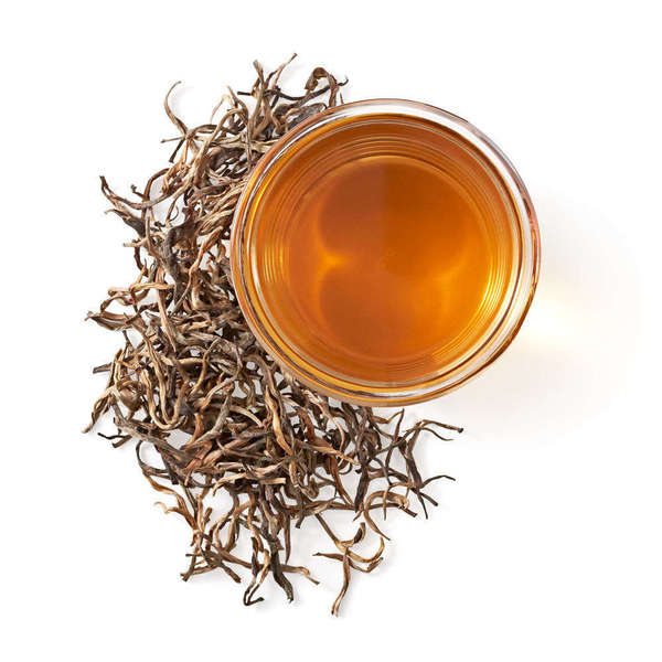 Cup of golden tea liquor, and yellow-orange, wiry loose-leaf tea