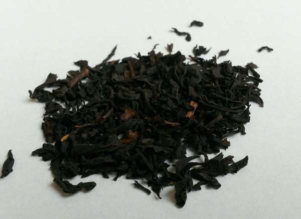 Dark, finely-broken black tea leaves