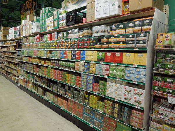 Colorful, packaged boxes of tea in a supermarket aisle