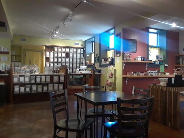 Tea shop with counter in distance, table in foreground, and indirect light coming through windows