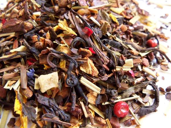 Colorful blend of tea leaves, mate, bright red fruits, straw-like lemongrass pieces, whole fruit, flower petals, and other ingredients