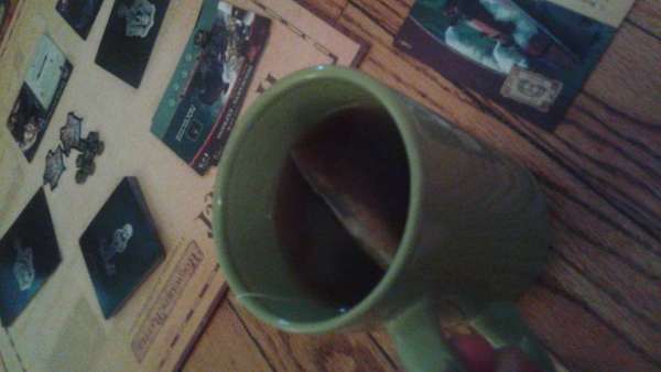 Green mug with teabag, Harry Potter: Hogwarts Battle card game in background