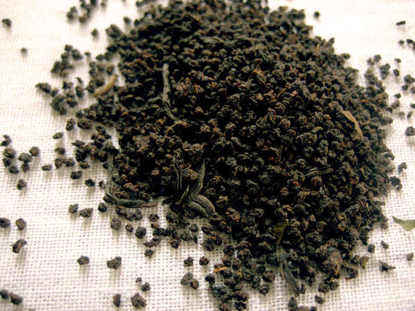 Loose-leaf CTC black tea showing fine pellets of regular shape, against a white mesh background