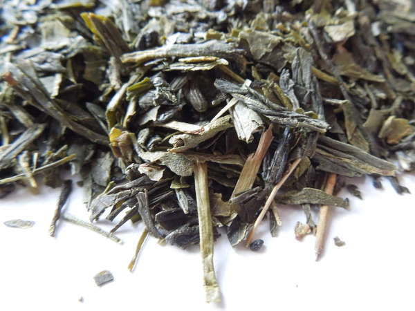 Loose-leaf green tea showing dark gray-green, brownish-green leaves, some stem
