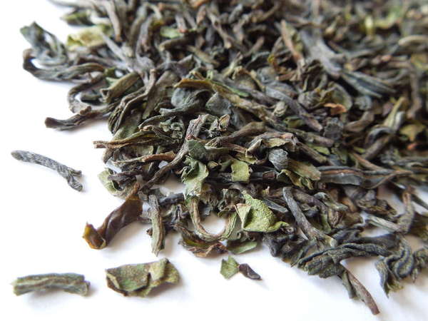 Loose-leaf tea with pale green to olive color, some buds with downy white hairs