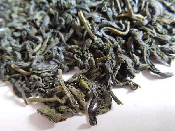 Loose-leaf green tea with dusty green color and twisted, wavy shape