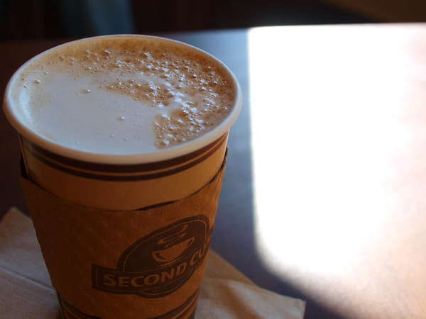 Foamy chai tea latte in to-go cup with Second Cup Coffee logo