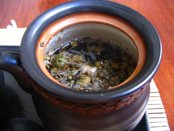 Mug filled with tea and dried flowers steeping