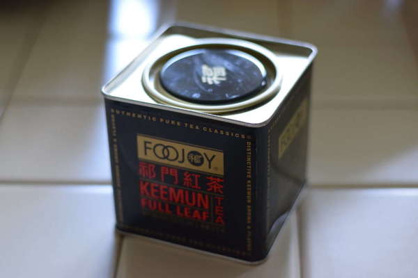Black tea tin with Foojoy logo, labeled Keemun Full Leaf, on a tile background