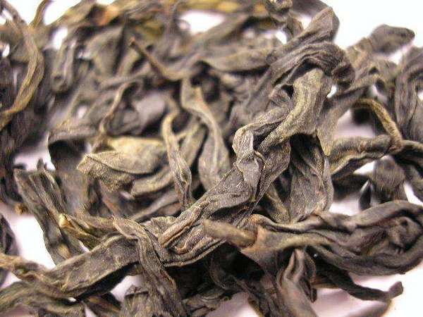 Closeup of twisted, olive-green  tea leaves with slight dusty texture