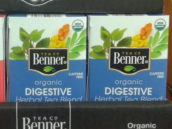 Closeup of 2 boxes of Benner Tea Co Organic Digestive Herbal Tea Blend, Blue Label, showing numerous herbs in picture behind logo