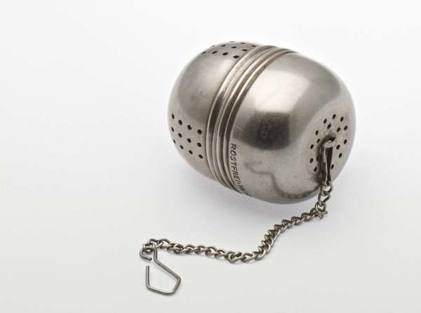 Stainless steel tea ball with only a few tiny holes for openings, and attached metal chain with hook on end