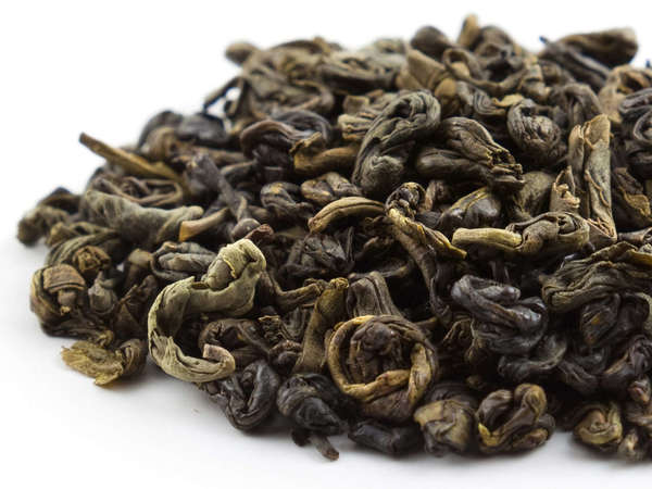 Loose-leaf green tea with tightly rolled leaves, olive green in color